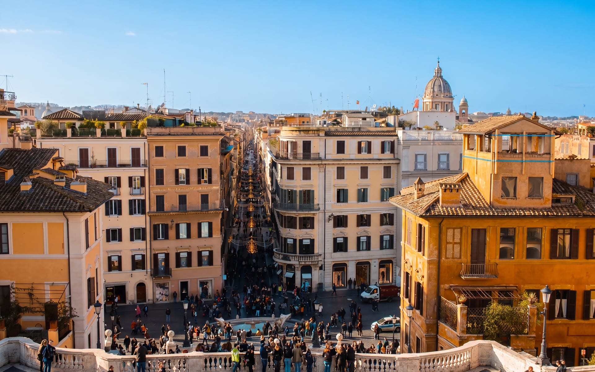 Veduta di Roma dalla cima di Trinità dei Monti lungo via dei Condotti, con una cupola e il cielo limpido