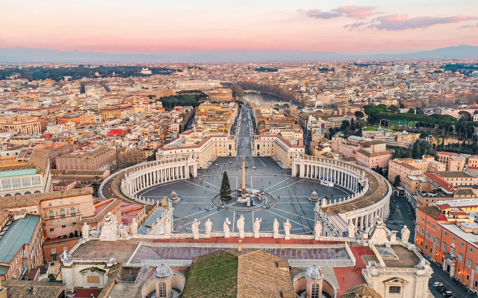 Veduta aerea di Piazza San Pietro e del Vaticano al tramonto, con il colonnato del Bernini e l'obelisco